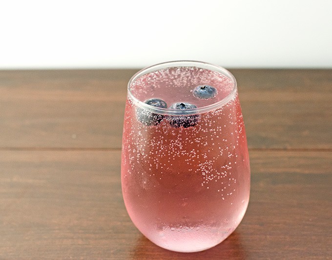 Mixed berry vodka spritzer in a glass stemless wine glass.