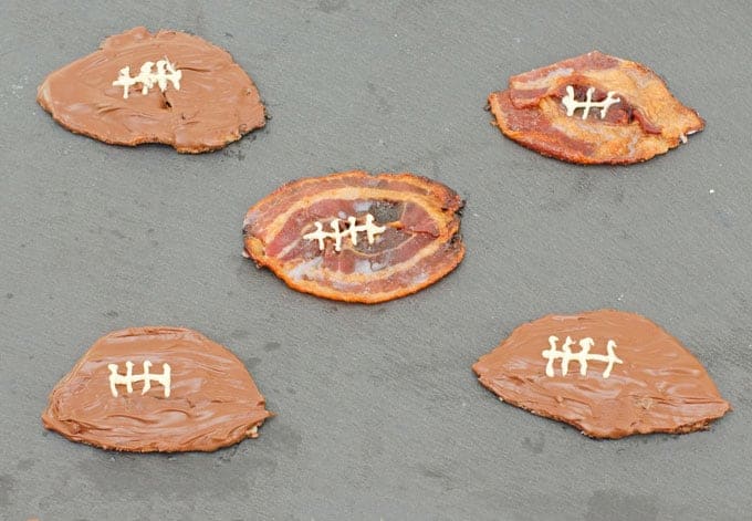Candied Bacon Footballs Recipe - Prepared Footballs sitting on a black slate serving platter
