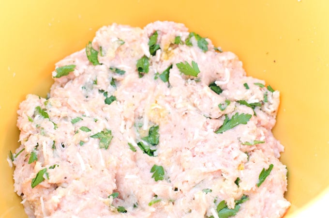 raw chicken parmesan meatball mix in a yellow bowl